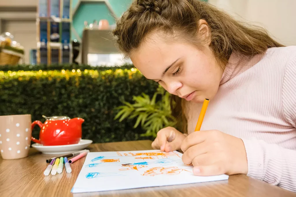 A young woman with down syndrome is painting